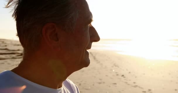 Lächelnder älterer Mann steht am Strand — Stockvideo