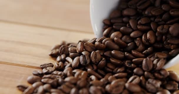 Roasted coffee beans spilling out of cup — Stock Video