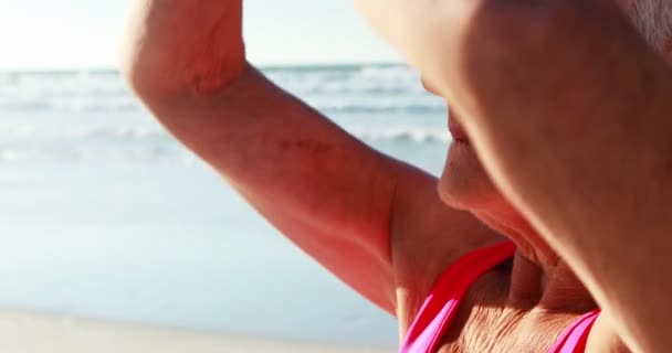 Femme âgée faisant du yoga à la plage — Video