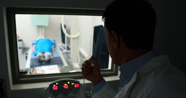 Médecin utilisant le panneau de commande de l'unité de rayons X sur le patient — Video