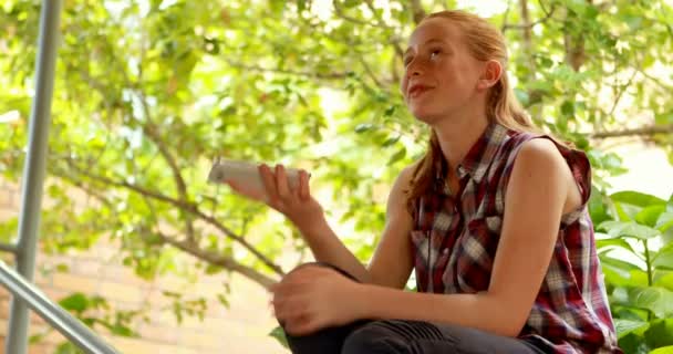 Happy schoolgirl using mobile phone — Stock Video