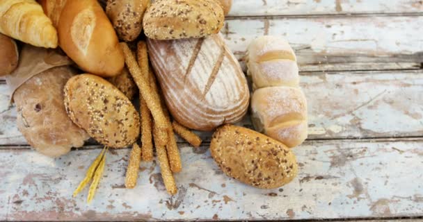 Various bread loaves on wooden table — Stock Video