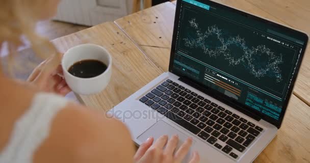 Mujer con taza de café mirando el modelo de ADN en el ordenador portátil — Vídeos de Stock