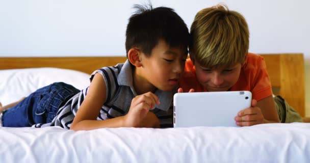 Siblings using digital tablet in bedroom — Stock Video