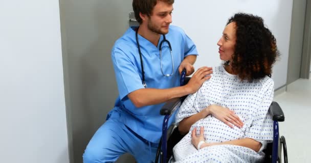 Doctor comforting pregnant woman in corridor — Stock Video