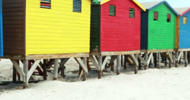 Pareja mayor bebiendo cerca de colorida cabaña de playa — Vídeo de stock