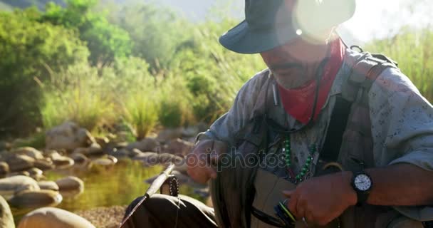 Mosca pescador preparando cuerda para atar en gancho — Vídeo de stock