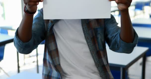 Schoolboy segurando cartaz com ajuda de texto em sala de aula — Vídeo de Stock