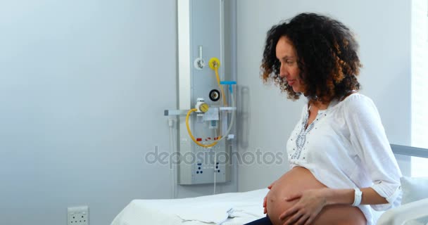 Man offering bunch of flowers to his pregnant woman in ward — Stock Video