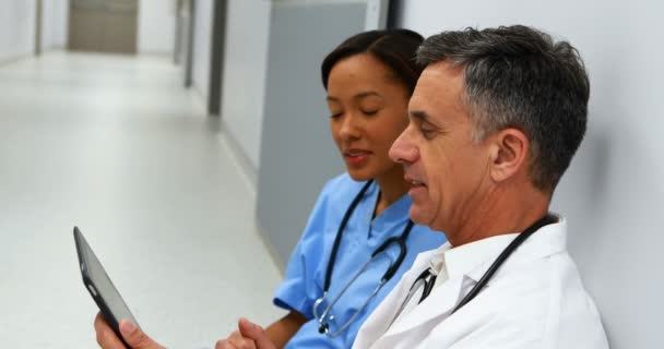 Médicos discutindo sobre tablet digital no corredor — Vídeo de Stock
