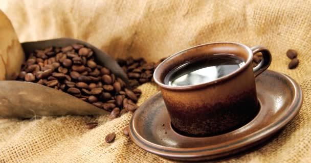 Černá káva, pražená zrna a lopatka na pytel — Stock video