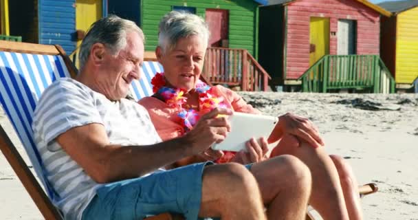 Couple âgé interagissant les uns avec les autres tout en utilisant une tablette numérique — Video