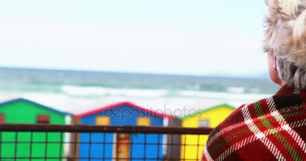 Mujer mayor disfrutando de la vista en la playa — Vídeos de Stock