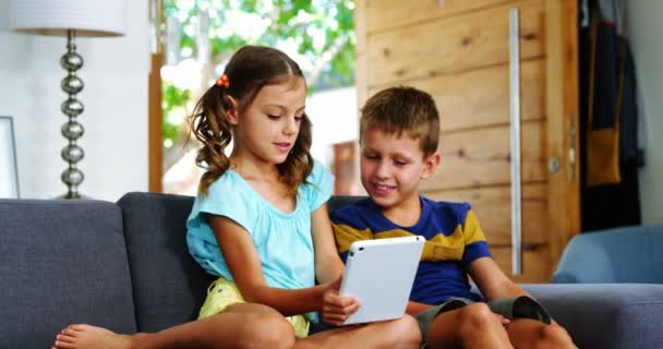 Broers en zussen met behulp van digitale tablet in woonkamer — Stockvideo