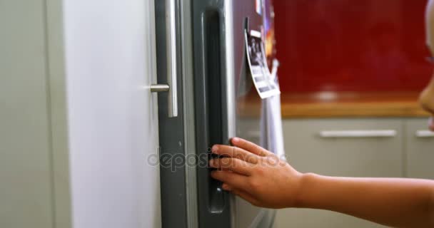Broers en zussen openen koelkast in keuken — Stockvideo