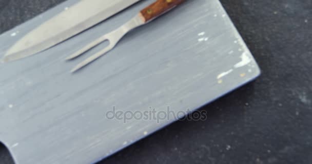 Нож крупным планом, вилка и деревянная доска — стоковое видео