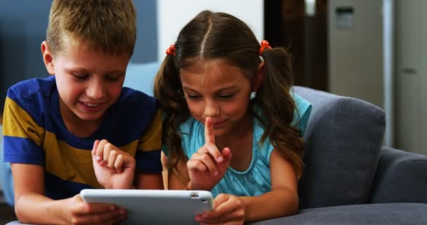 Hermanos usando tableta digital en sala de estar — Vídeos de Stock