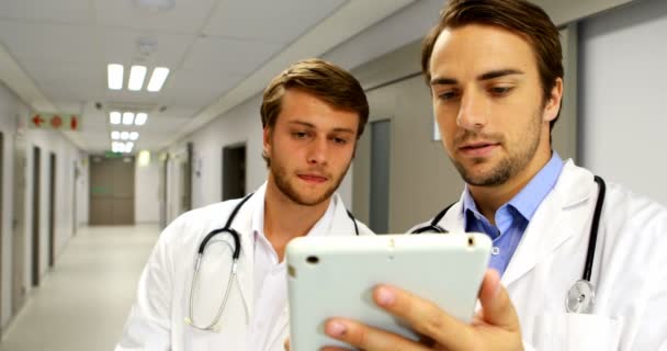 Lékaři diskutovat nad digitálním tabletu v chodbě — Stock video