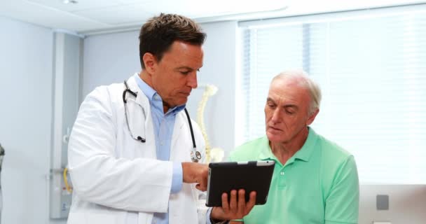 Médico y paciente senior discutiendo sobre tableta digital — Vídeos de Stock