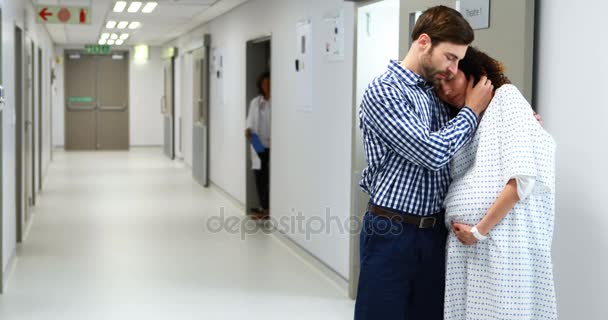 Homem abraçando mulher grávida no corredor — Vídeo de Stock