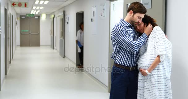 Man embracing pregnant woman in corridor — Stock Video