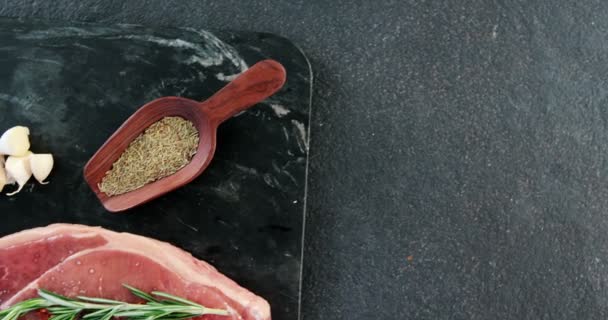 Raw sirloin chop, garlic, rosemary, and spice — Stock Video