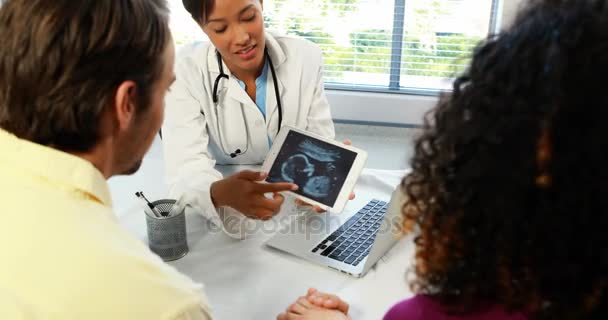 Lékařka s digitálním tabletu zobrazeno ultrazvukové vyšetření dítěte páru — Stock video