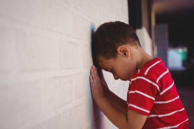 boy leaning on wall at school clipart