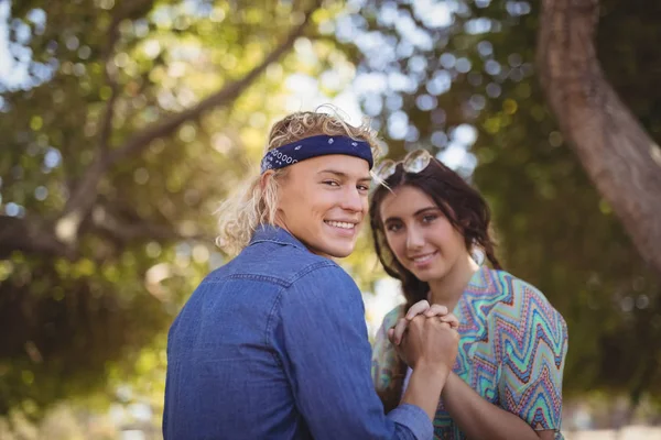 Par innehav händer mot träd — Stockfoto