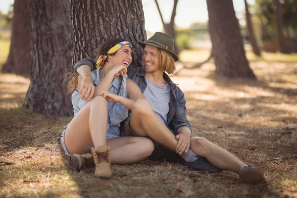 Pareja sentada por árbol tronco —  Fotos de Stock