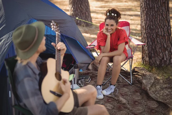 Woman looking at her boyfriend playing guitar — Stock Photo, Image