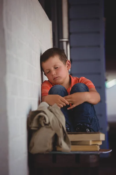 Pojken sitter på bänken av vägg — Stockfoto