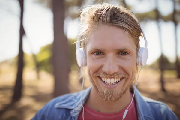 Muž poslouchající hudbu na sluchátkách — Stock fotografie