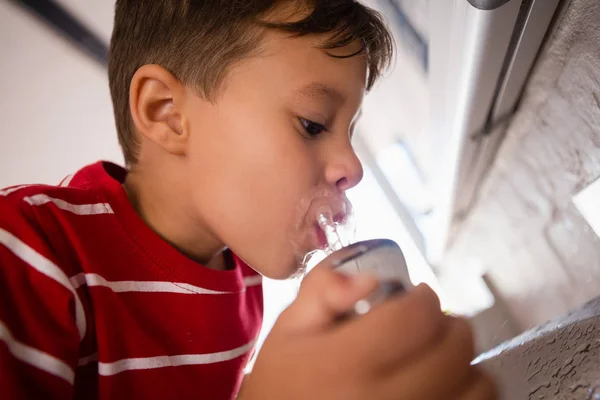 Jongen drinkwater uit de kraan — Stockfoto