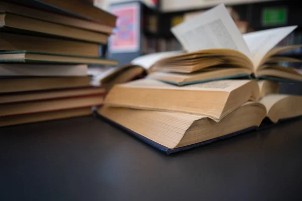 Bücher auf Tisch gegen Regal in Bibliothek — Stockfoto
