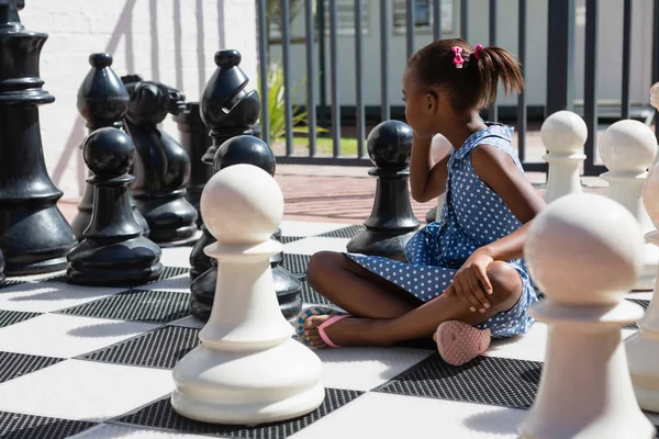 Дівчина сидить за шаховими фігурами — стокове фото