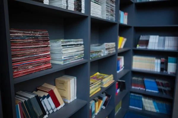 Livros dispostos em prateleiras na biblioteca — Fotografia de Stock