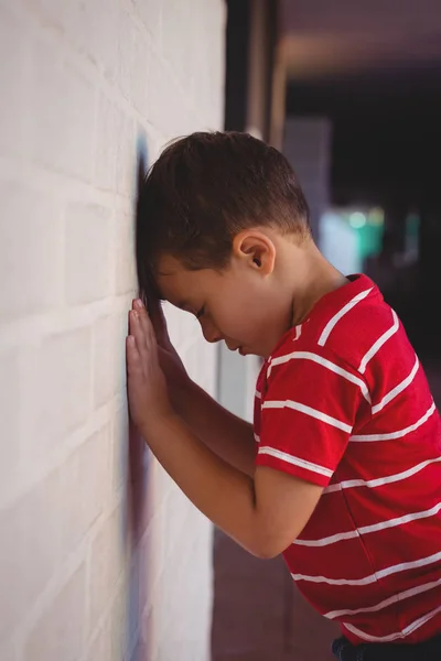 Üzgün çocuk duvara yaslanmış — Stok fotoğraf
