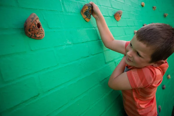 Niño escalando en la pared de ladrillo — Foto de Stock