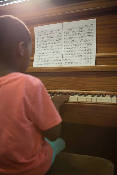 Pojke praktiserande piano i klassrummet — Stockfoto