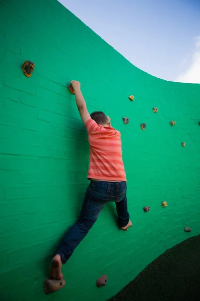 Junge klettert auf grüne Wand — Stockfoto