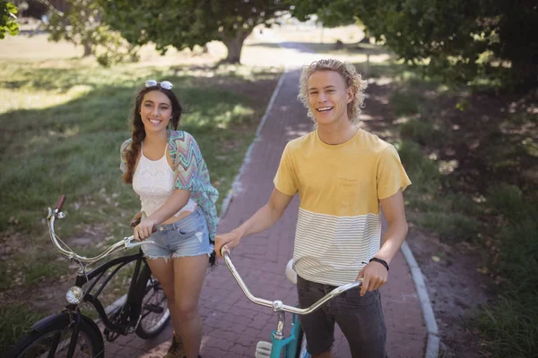 Uomo e donna in piedi con biciclette — Foto Stock