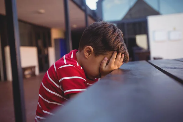Tired boy leaning on table — Stock Photo, Image