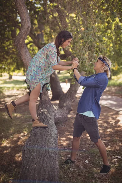 Casal brincando no tronco da árvore — Fotografia de Stock
