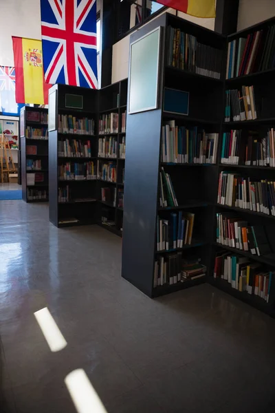 Flags by bookshelf in library — Stock Photo, Image