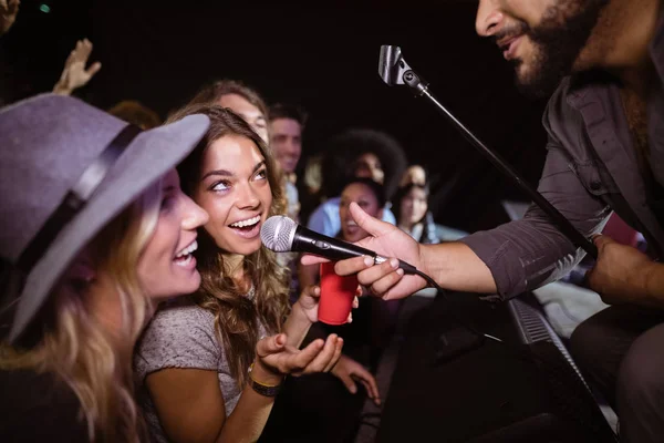 Friends singing with male singer — Stock Photo, Image