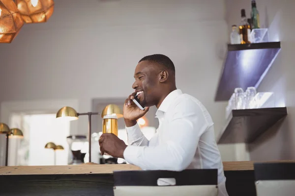 Hombre hablando en el teléfono móvil mientras toma cerveza — Foto de Stock