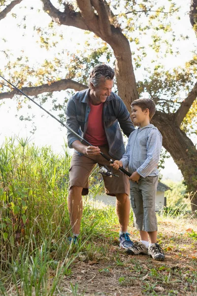 Far och son talar medan fiske — Stockfoto