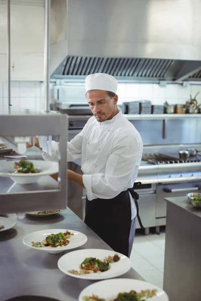 Chef guardando una lista degli ordini in cucina — Foto Stock