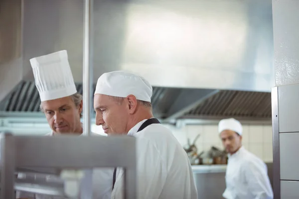 Chefs preparando comida en la cocina comercial — Foto de Stock